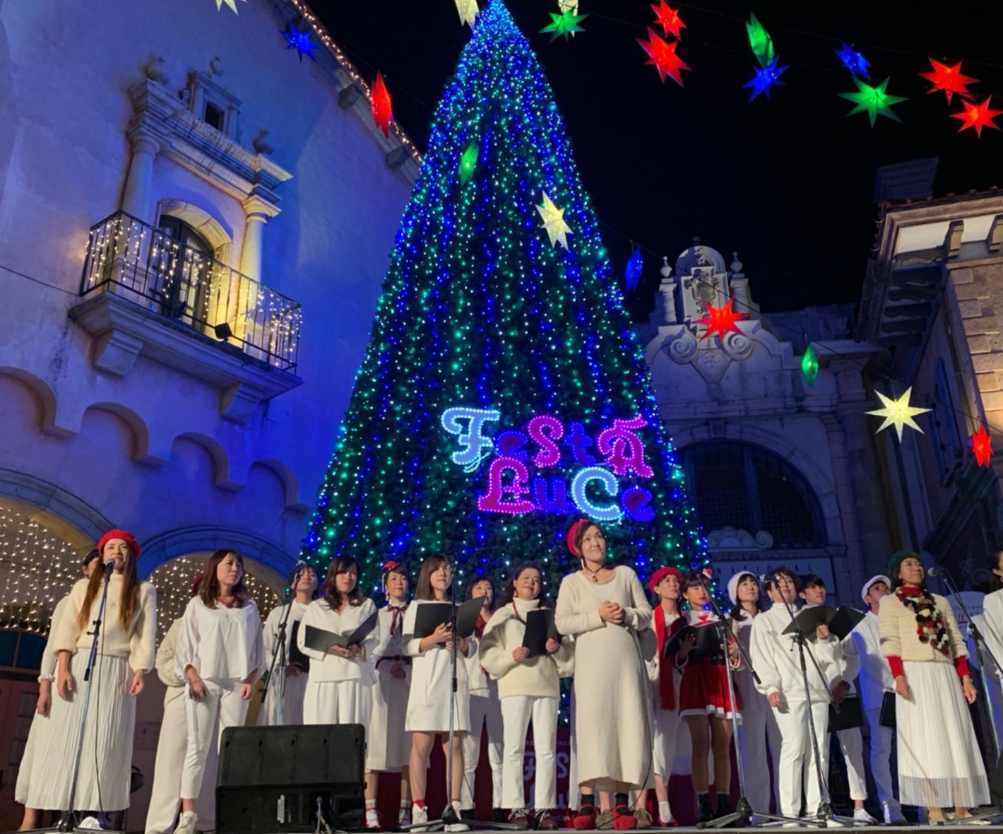 クリスマスツリーの前で合唱をする生徒たち